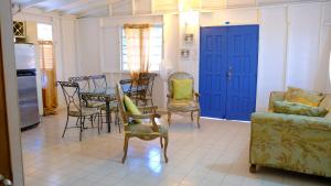 a living room with chairs and a table and blue doors at Comoda casa en segunda planta in Coamo