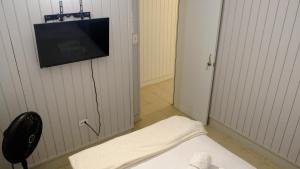 a room with a tv on a wall with a bed at Comoda casa en segunda planta in Coamo
