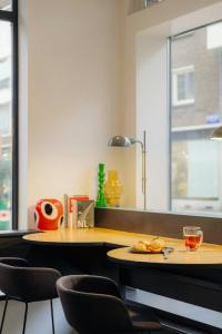 a kitchen with two tables and chairs and a counter at Leonardo Hotel Rotterdam Savoy in Rotterdam +29 photos