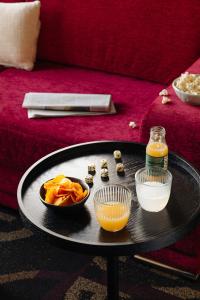 a table with a bowl of food and a bottle of orange juice at Leonardo Hotel Den Haag Babylon in The Hague
