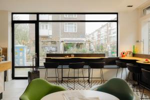 a restaurant with tables and chairs and a large window at Leonardo Hotel Rotterdam Savoy in Rotterdam