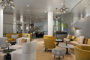 a lobby with couches and chairs and tables at Leonardo Hotel Mainz in Mainz