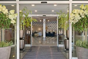 a lobby with glass doors and potted plants at Leonardo Hotel Mainz in Mainz