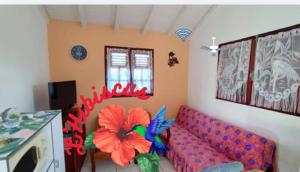 a living room with a couch with a flower on it at L'hibiscus in Petit-Canal