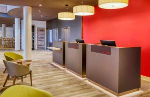 an office with a red wall and desks and chairs at Hotel Nürnberg City Center by Leonardo Hotels in Nuremberg