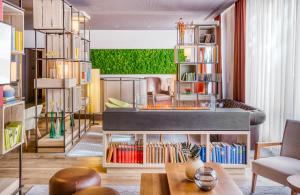 a living room with a bed and bookshelves at Hotel Nürnberg City Center by Leonardo Hotels in Nuremberg +24 photos