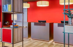 an office with red walls and desks with books at Hotel Nürnberg City Center by Leonardo Hotels in Nuremberg