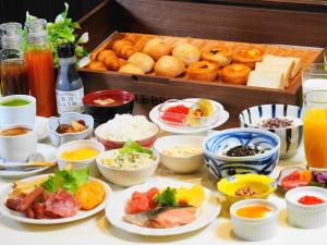 a table topped with plates of food and other foods at Asahikawa Sun Hotel in Asahikawa