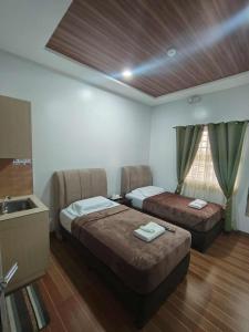 a hotel room with two beds and a sink at Mizpah Apartelle in Tagbilaran City