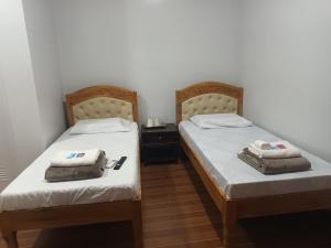 two beds sitting next to each other in a room at Mizpah Apartelle in Tagbilaran City +9 photos