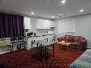 a kitchen and living room with a table and a couch at Cobourg Inn in Cobourg