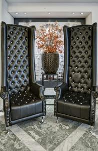 two black leather chairs in a room with a table at Leonardo Hotel München City West in Munich
