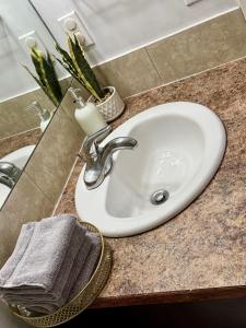 a white sink in a bathroom with a mirror at Cozy 1-Bed Basement Suite in Calgary +26 photos