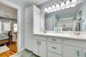 a bathroom with two sinks and a mirror at Happy Hours in Carolina Beach +29 photos