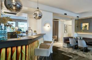 a lobby with a bar with chairs and a table at Leonardo Hotel München City West in Munich +45 photos