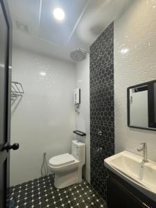 a bathroom with a white toilet and a sink at D'Anjung Cottage Paka in Paka +48 photos