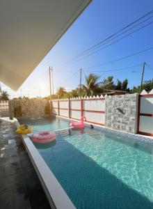 a swimming pool with two pink flamingos in it at D'Anjung Cottage Paka in Paka