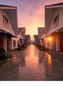 an empty driveway between two houses at sunset at D'Anjung Cottage Paka in Paka