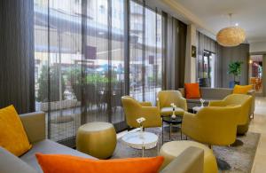 a waiting room with yellow and orange chairs at Leonardo Hotel Budapest in Budapest