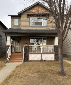 a house with a porch and a white fence at Cozy 1-Bed Basement Suite in Calgary