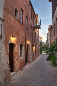 un callejón en un edificio antiguo con balcón en C&M Residence Chania Old Town en La Canea