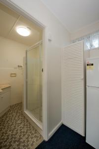 a bathroom with a shower, sink, and toilet at Mineral Sands Motel in Maryborough