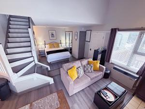 a living room with a staircase and a couch and a bed at Slopeside Loft at North Creek Resort in Blue Mountains