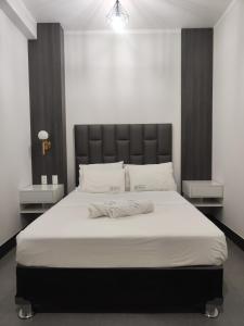 a bedroom with a large bed with a black headboard at Hospedaje Bry Ker in Pichanaki