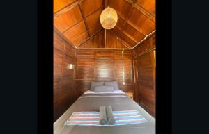 a small bed in a boat with a wooden ceiling at Kahurangi Hotel in Sekongkang +44 photos