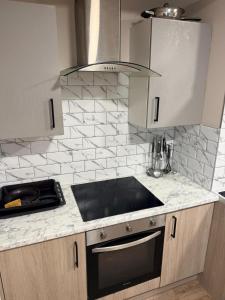 a kitchen with a stove and a counter top at Modern Studios Epsom Station in Epsom +33 photos
