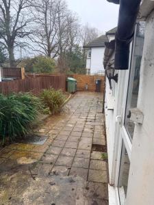 a yard with a fence and a brick walkway at Modern Studios Epsom Station in Epsom