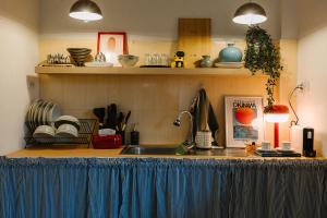 a kitchen with a sink and a counter with dishes at Kawish House กาวิส เฮ้าส์ in Ban Hua Trut