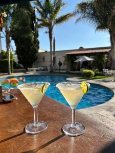 two martinis sitting on a table next to a swimming pool at Suite vista hermosa in San Miguel de Allende