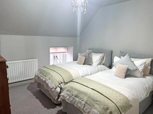 a bedroom with two beds and a chandelier at John Wesley Cottage in Tantobie +3 photos