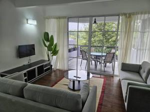 a living room with a couch and a table at Fraser's Haven SilverparkResort Walk down 8 steps in Bukit Fraser