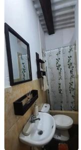 a bathroom with a sink and a toilet and a mirror at Sunset bed in Puerto Chicama