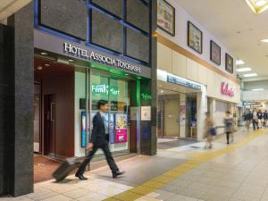 a man walking in front of a shopping mall at Hotel Associa Toyohashi in Toyohashi +94 photos