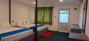 a small room with two beds and a window at Bhagya Resort Limited in Nikawatawana +10 photos