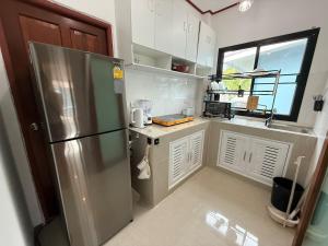 a kitchen with a stainless steel refrigerator and a window at Very Central Boho Home in Srithanu in Ko Kong Nui