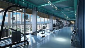 a gym with several treadmills and machines in a building at Stallionz by KLIQ in Ipoh