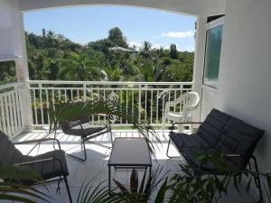 a balcony with chairs and a table and a view at LE VERDOYANT in Sainte-Anne