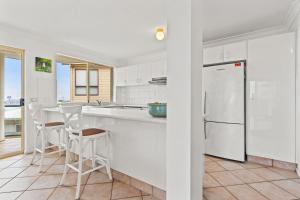 a kitchen with white cabinets and a white refrigerator at Shelly Vista in East Ballina