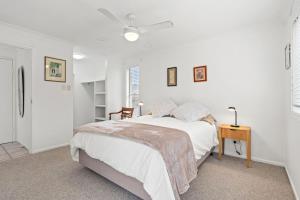 a white bedroom with a bed and a table at Shelly Vista in East Ballina +17 photos