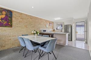 a kitchen and dining room with a table and chairs at Ballina Golf Unit in East Ballina