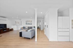 a living room with a couch and a table at Baileys Beach House in East Ballina