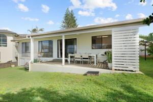 a house with a patio and a table at Baileys Beach House in East Ballina