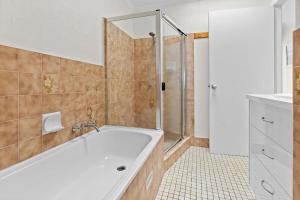 a bathroom with a tub and a shower at Sun Soaked Lennox Village in Lennox Head +25 photos