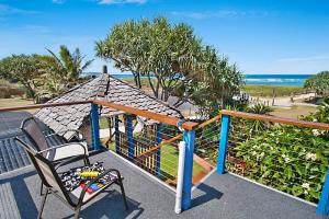 a balcony with a chair and a view of the ocean at Beach House in Lennox Head