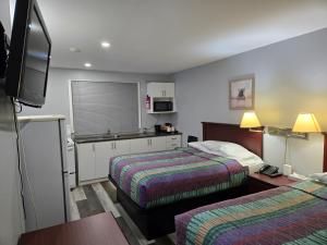a hotel room with two beds and a television at Cobourg Inn in Cobourg