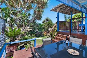 a table with a plate of food on a deck at Beach House in Lennox Head